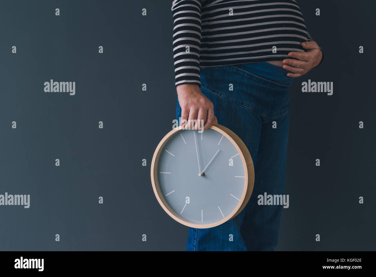 Les femmes enceintes avec vintage réveil attend bébé dans le troisième trimestre de la grossesse Banque D'Images