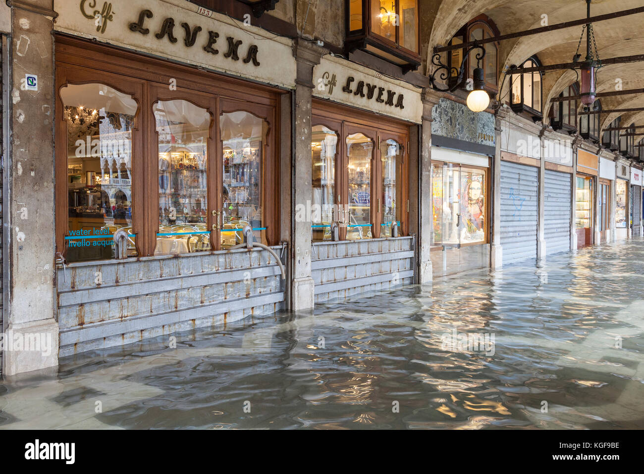 Venise, Vénétie, Italie. Nov 7, 2017. Acqua Alta marée haute de 115cm à partir de la lagune provoquant des inondations temporaires sur la Piazza San Marco. Les locaux fermés de la Caffe Lavena avec de l'eau métallique barrières en place et le tuyau d'une pompe à eau. Indiqué sur leur fenêtre est la marque de la marée haute ou de l'eau niveau de l'inondation 1966 devestating Acqua Alta. Credit : Mary Clarke/Alamy Live News Banque D'Images