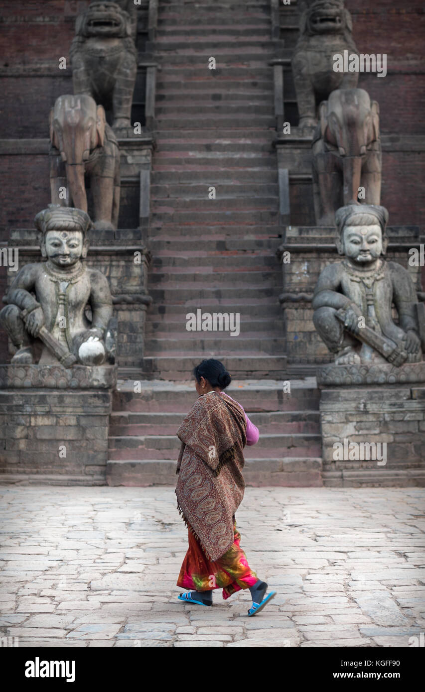 Femme marche devant un temple à Bhaktapur, Népal Banque D'Images