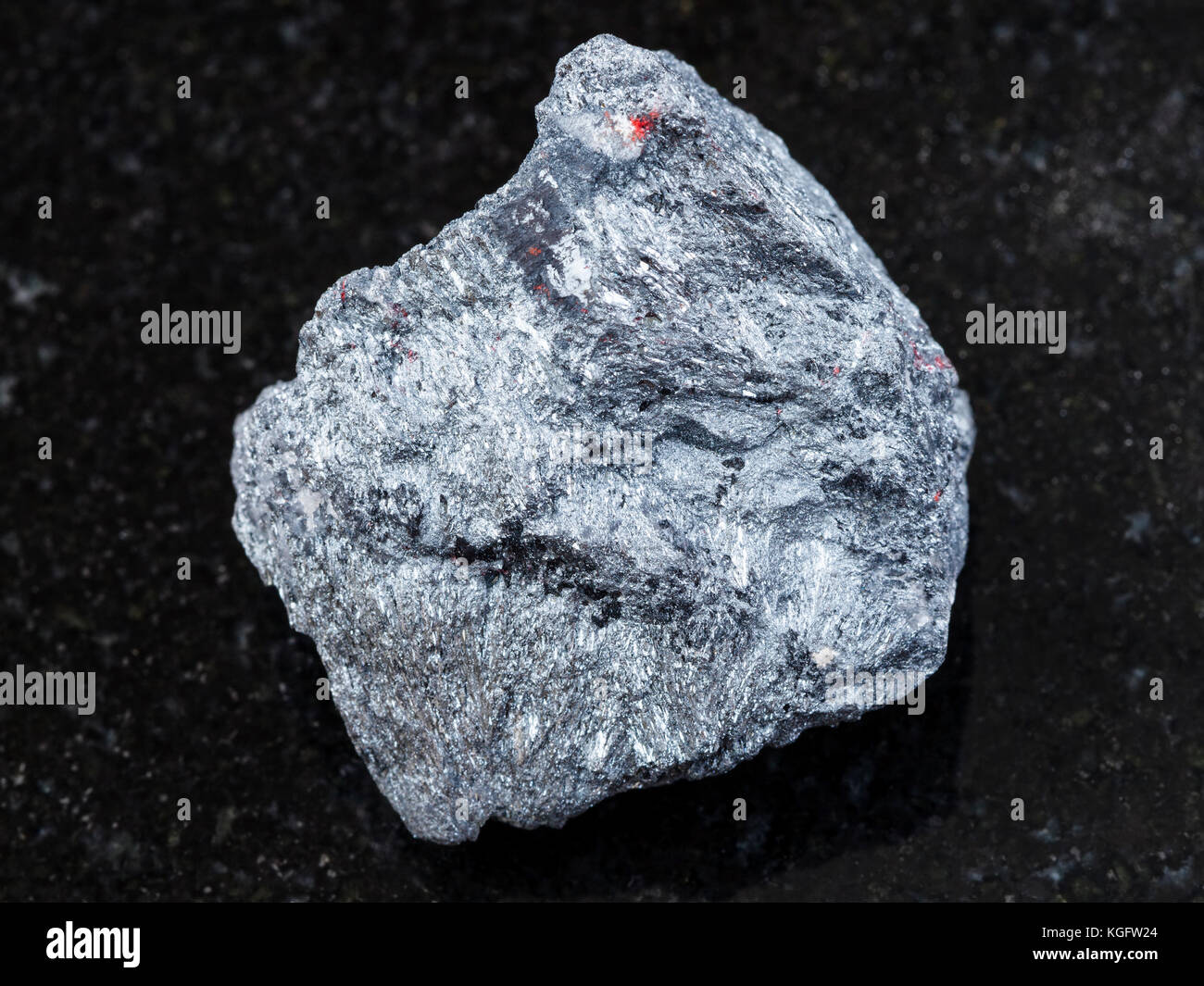 La prise de vue macro des eaux minérales naturelles rock specimen - matières premières (minerai d'antimoine la stibnite) sur la pierre de granit sombre arrière-plan de l'ukraine Banque D'Images