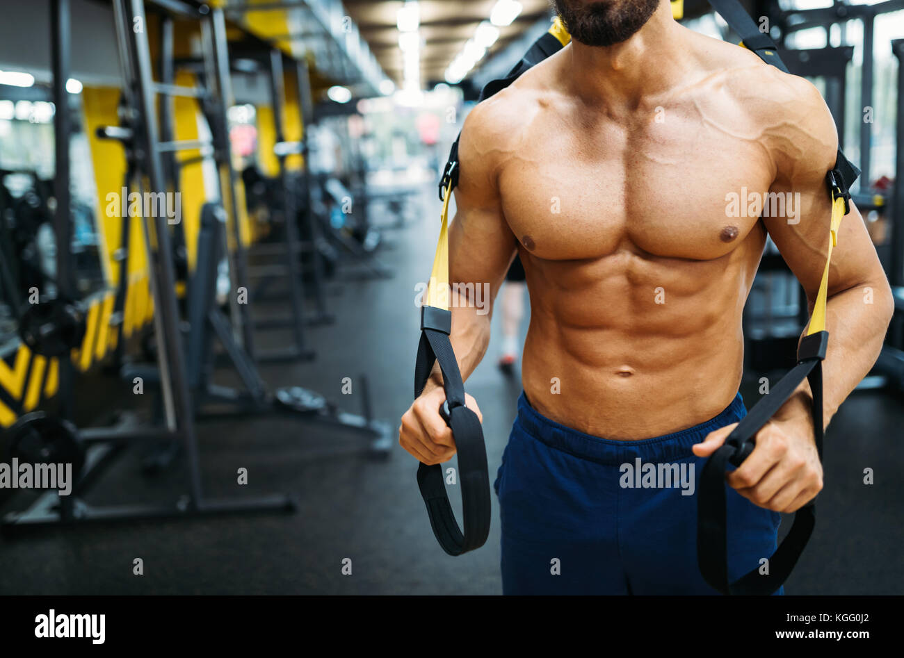 Young handsome man doing exercises in gym Banque D'Images