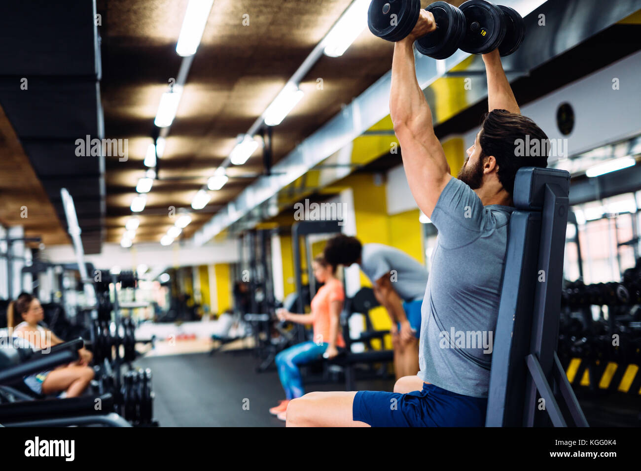 Young handsome man doing exercises in gym Banque D'Images