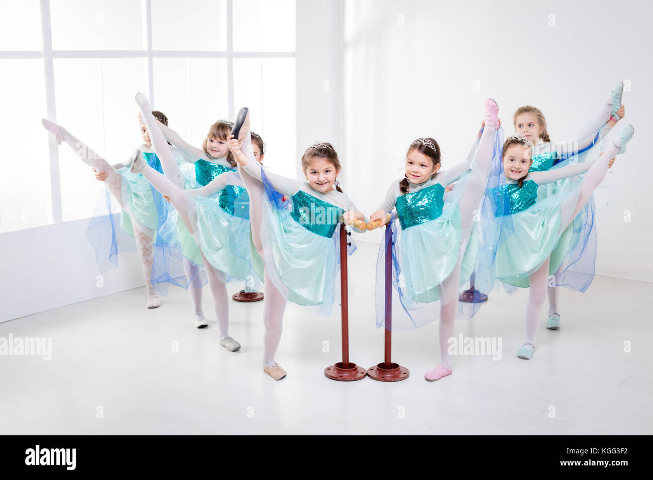 Groupe de filles à l'aide de barre tout en pratiquant dans un studio de danse. Banque D'Images