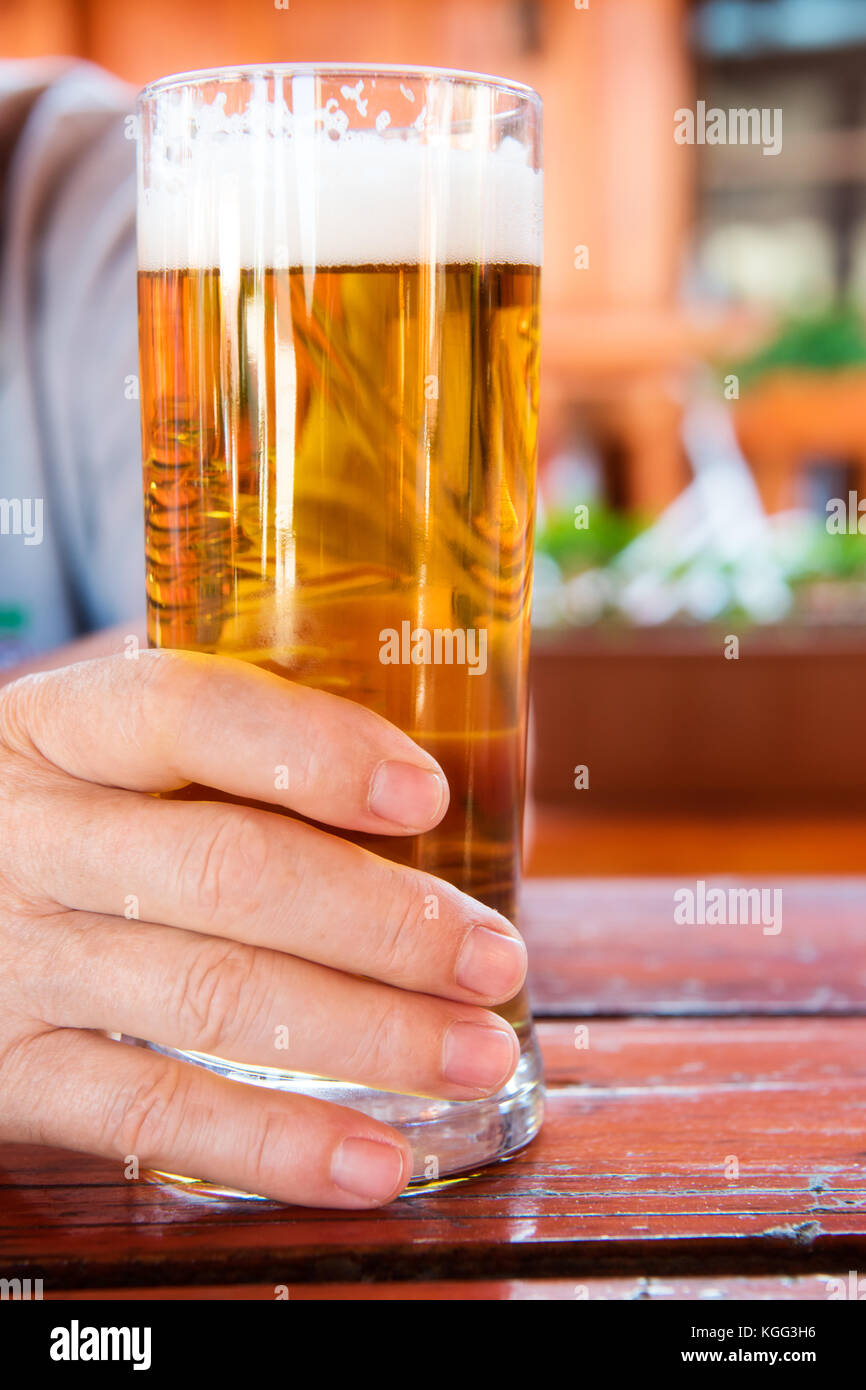 Homme main tenant un verre de bière pression Banque D'Images
