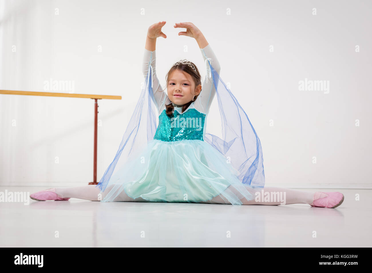 Cute smiling little girl practicing ballet et à la recherche à l'appareil photo. Banque D'Images