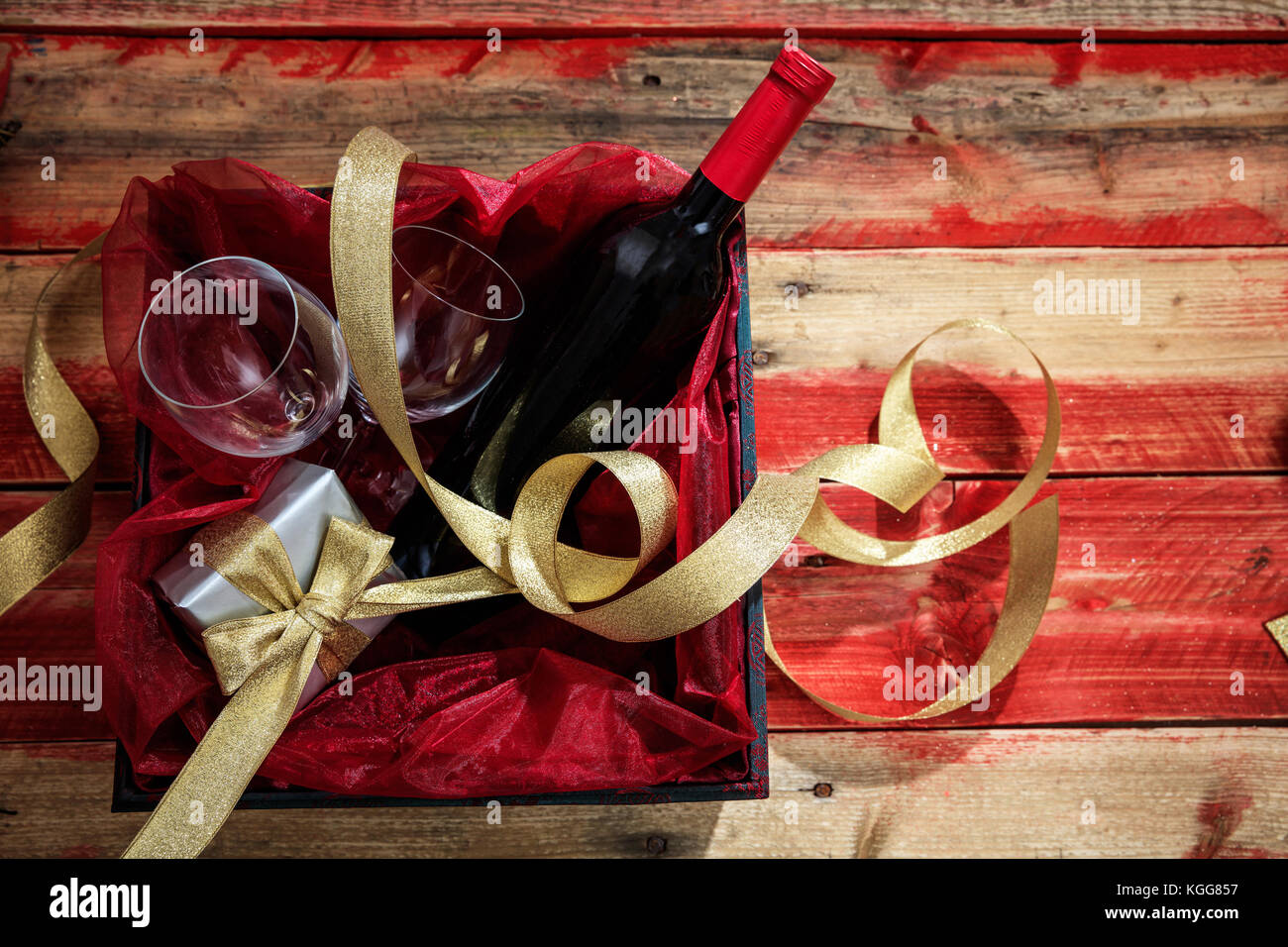 Valentines Day concept. Bouteille de vin rouge, des lunettes et un cadeau dans une boîte en bois, avec fond copyspace Banque D'Images