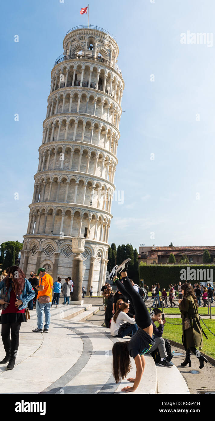Les jeunes n'touristique un saut périlleux en face de la tour penchée de Pise pendant que quelqu'un se mette sa photo Banque D'Images