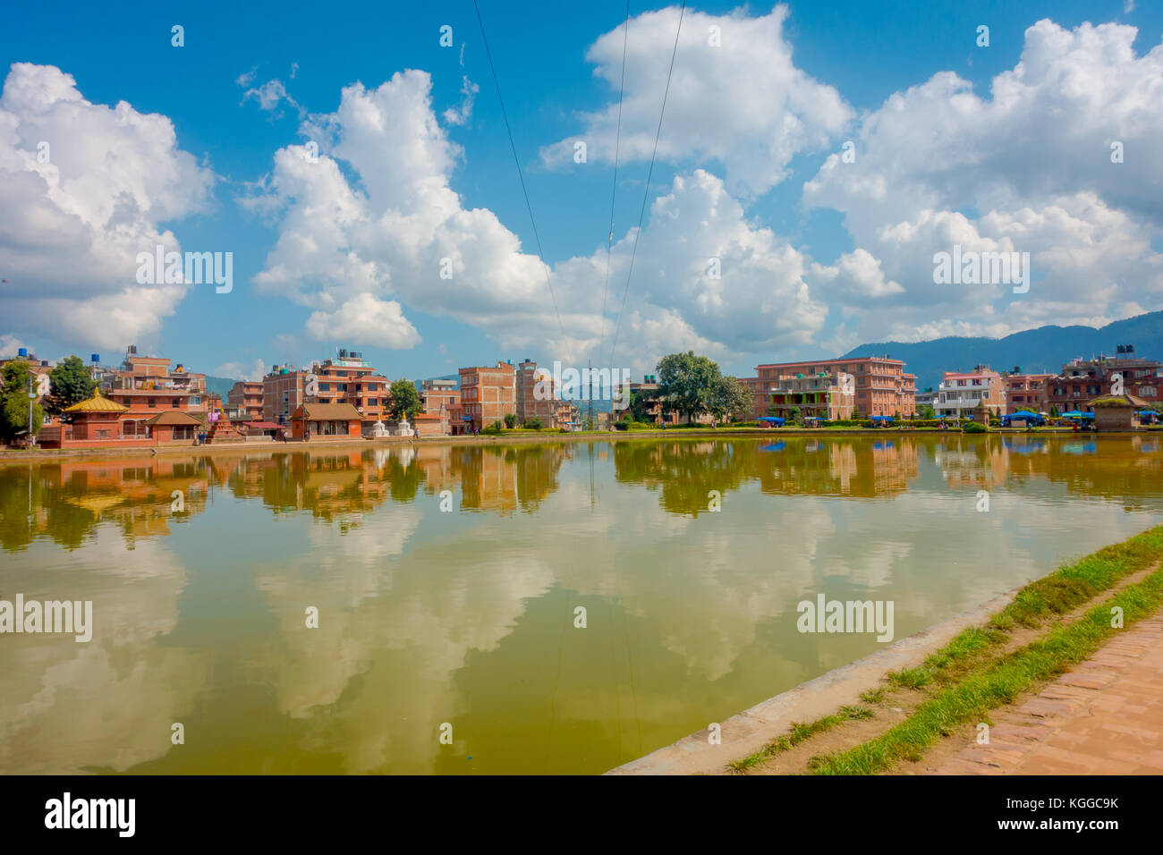 BHAKTAPUR, NÉPAL - 04 NOVEMBRE 2017 : gros plan de la scène urbaine traditionnelle floue avec un étang artificiel d'eau jaune dans la ville de Bhaktapur, Népal Banque D'Images BHAKTAPUR, NÉPAL - 04 NOVEMBRE 2017 : gros plan de la scène urbaine traditionnelle floue avec un étang artificiel d'eau jaune dans la ville de Bhaktapur, Népal Banque D'Images