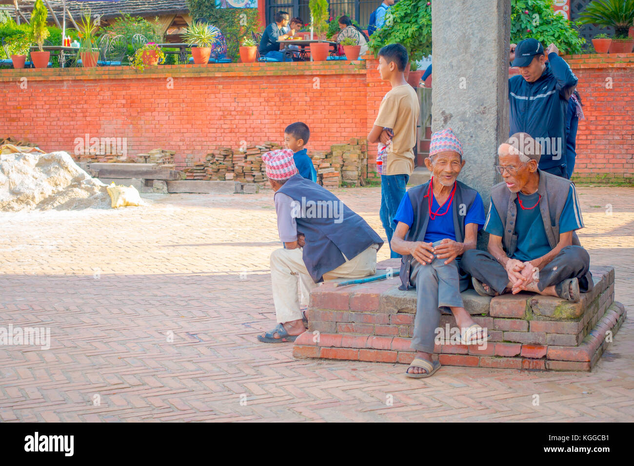 BHAKTAPUR, NÉPAL - 04 NOVEMBRE 2017 : personnes non identifiées à l'extérieur assis dans l'entrée de l'ancien temple hindou sur la place Durbar à Bhaktapur, c'est la ville avec plus de temples pour la région Banque D'Images BHAKTAPUR, NÉPAL - 04 NOVEMBRE 2017 : personnes non identifiées à l'extérieur assis dans l'entrée de l'ancien temple hindou sur la place Durbar à Bhaktapur, c'est la ville avec plus de temples pour la région Banque D'Images