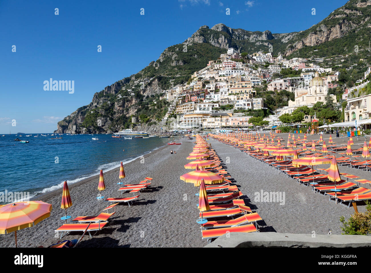 Président et des parasols colorés la ligne plage Spiaggia Grande, à Positano, Italie. Eaux bleues de la mer Tyrrhénienne. Banque D'Images