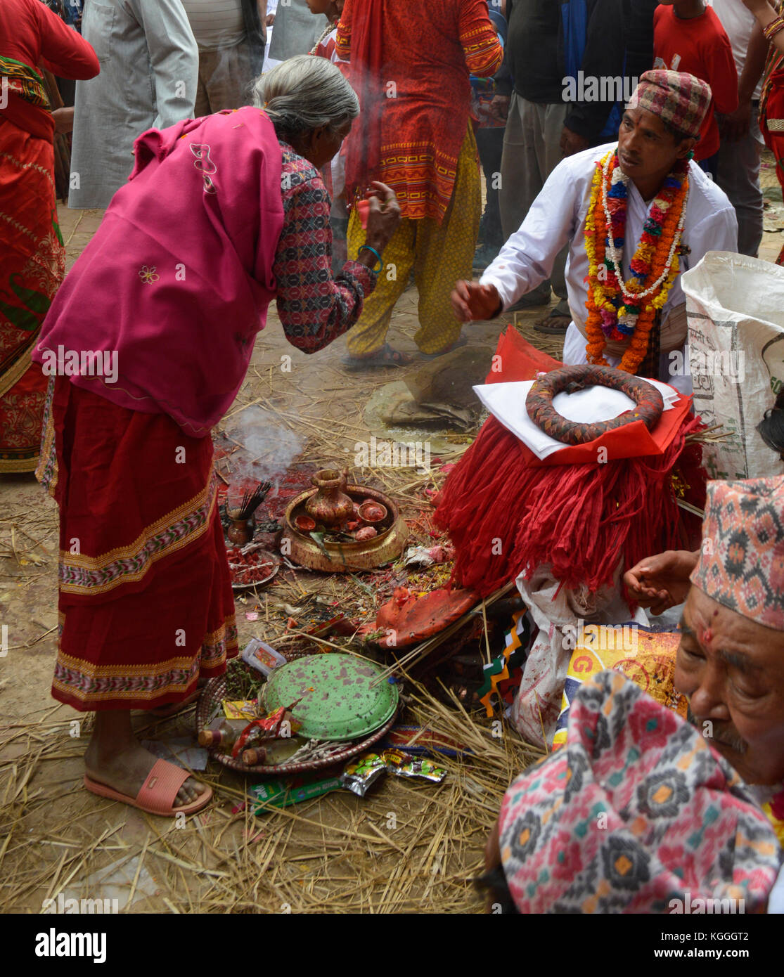 Ancienne femme népalaise offrant aux dieux pendant le festival de jatra à Panauti, au Népal. Les dieux viennent dans le petit village pendant 3 jours de fête. fumée d'incitation. Banque D'Images