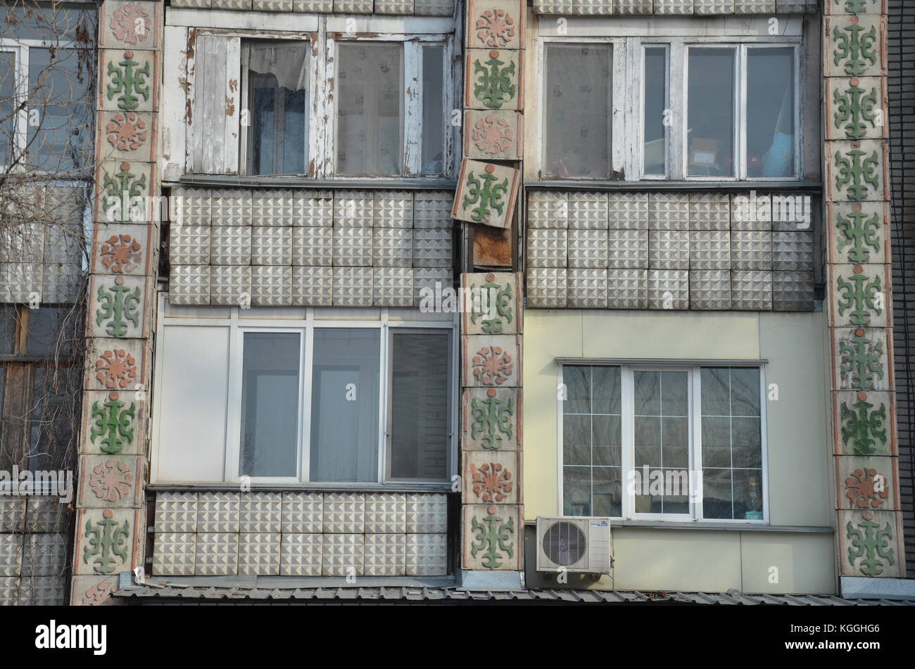 De vieux carreaux décorés tombent de la façade d'un ancien immeuble soviétique à Kakakhstan. refuser. construction rapide. en train de se détacher, toujours en cours d'utilisation, façade Banque D'Images