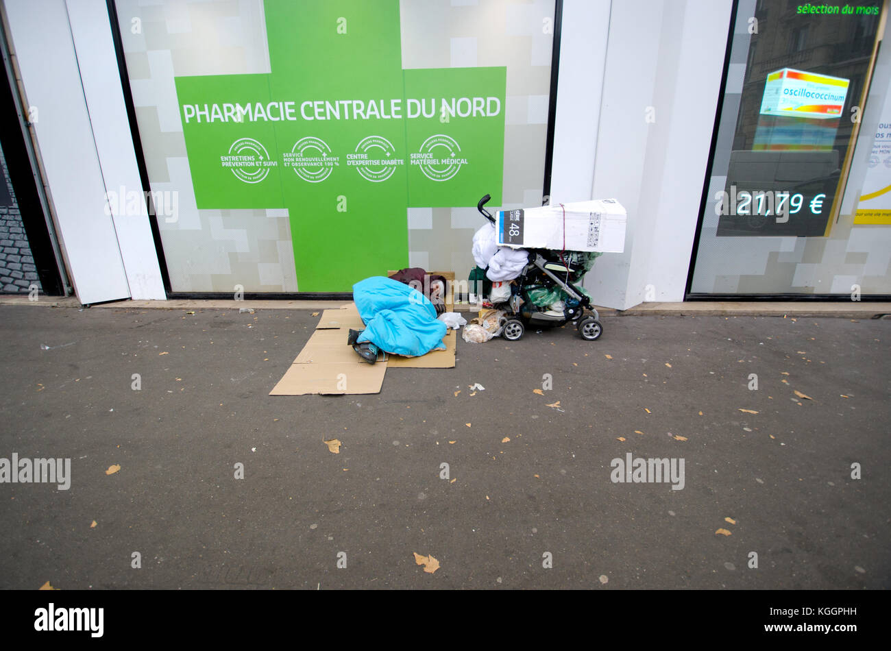 Paris, France. Personne sans-abri dorment dans la rue en dehors d'une pharmacie à proximité de la Gare du Nord Banque D'Images