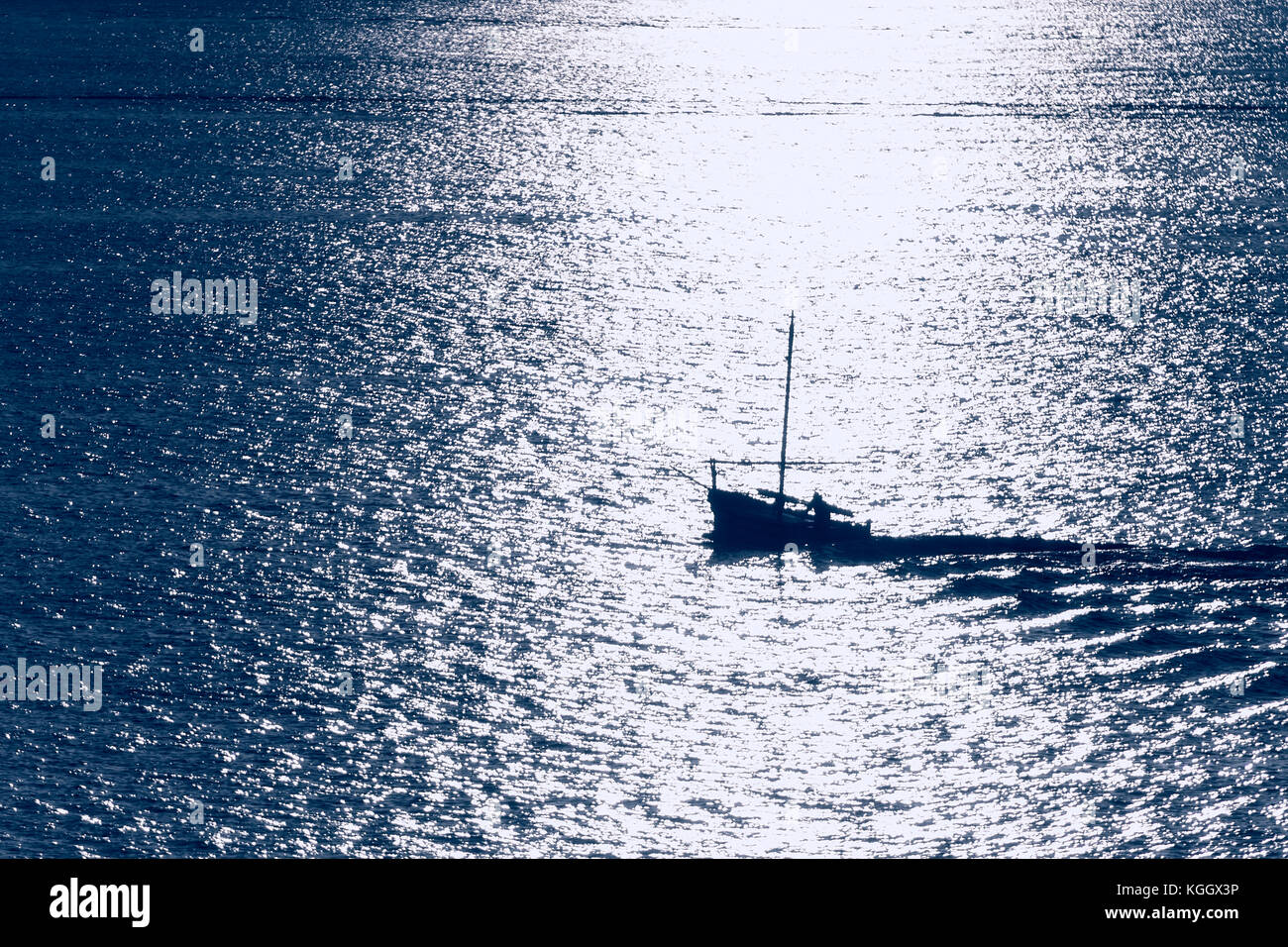 Petit bateau de pêche au lever du soleil sur la mer méditerranée, Alghero, Sardaigne, Italie. Banque D'Images
