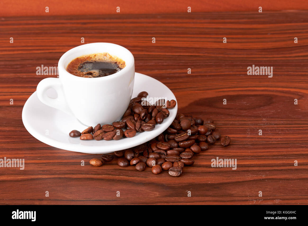 Tasse de café avec les grains de café sur fond de bois Banque D'Images