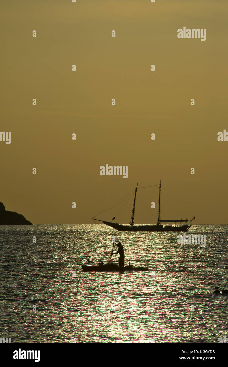Pêcheur dans une barque au coucher du soleil Banque D'Images