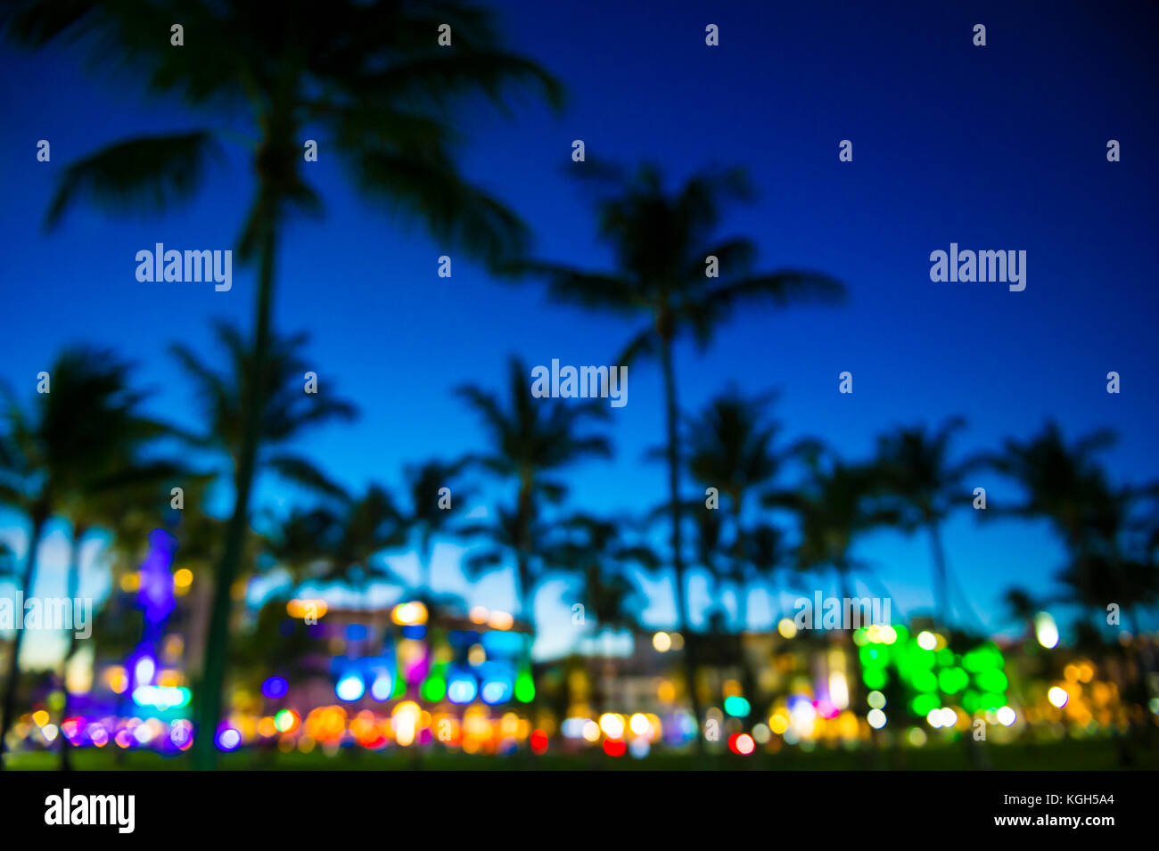 Vue de flou artistique au crépuscule de palmiers et de néons d'Ocean Drive à South Beach, Miami, Floride. Banque D'Images
