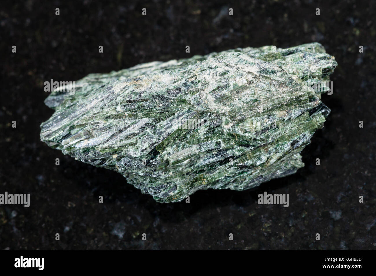 La prise de vue macro des eaux minérales naturelles rock specimen - rough actinolite pierre sur fond de granit sombre de verkhny ufaley, district de l'Oural, Russie Banque D'Images