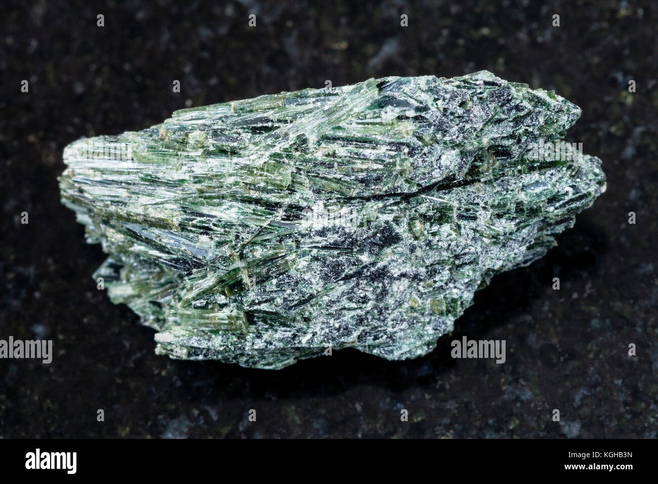 La prise de vue macro des eaux minérales naturelles rock specimen - brut de l'actinolite pierre sur fond de granit sombre de verkhny ufaley, district de l'Oural, Russie Banque D'Images