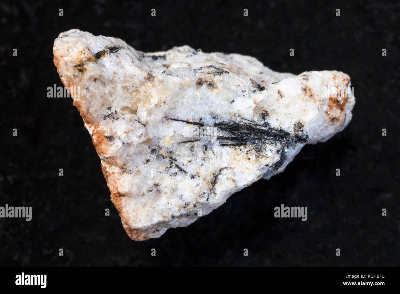 La prise de vue macro des eaux minérales naturelles rock specimen - noir cristaux ludwigite en pierre brute sur fond de granit sombre de praskovie-evgenyevskaya la mienne, Banque D'Images