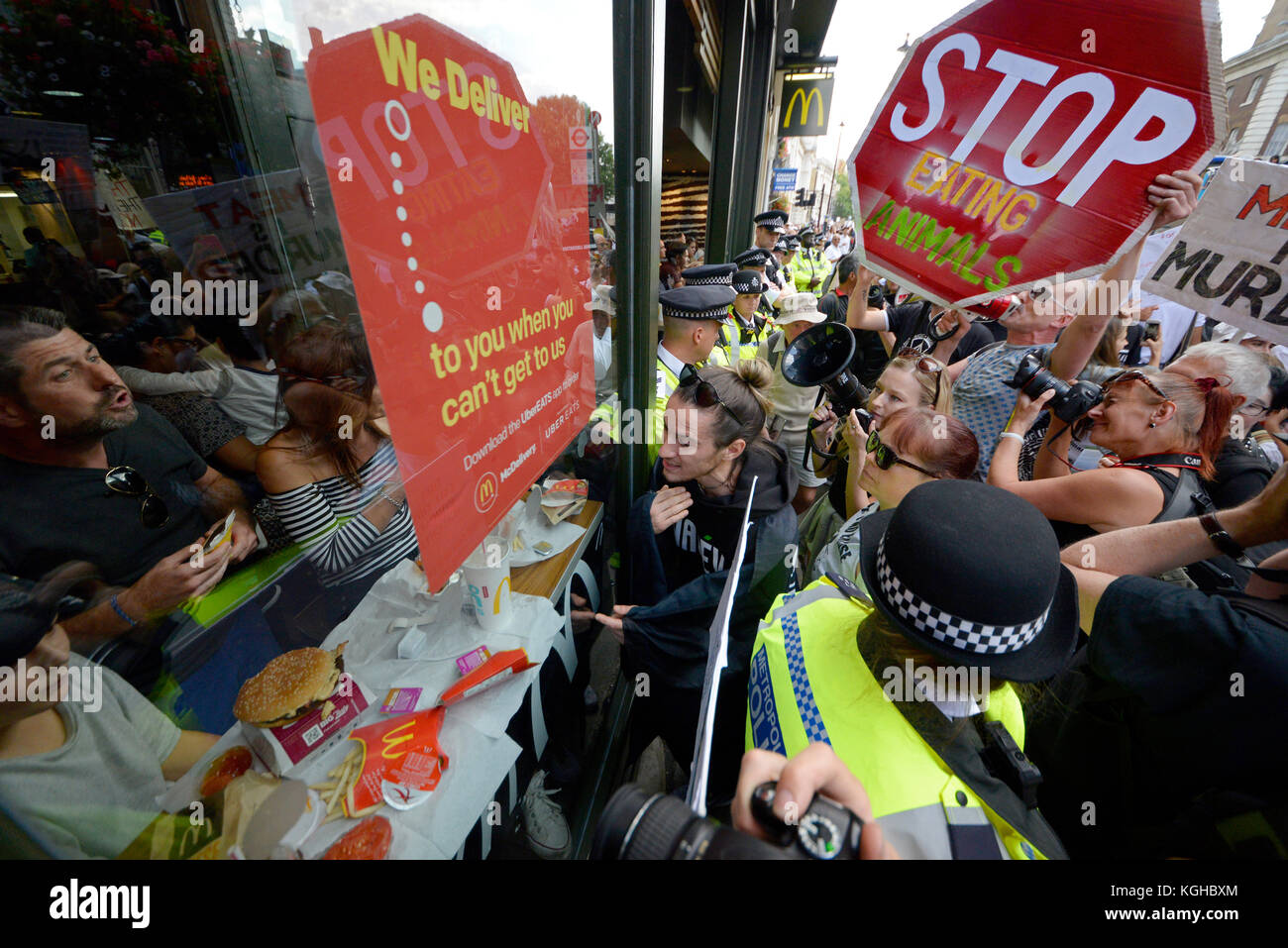 Les activistes végétaliens assiégeant un restaurant McDonalds dans Whitehall Londres pendant une manifestation de protestation pour les droits des animaux mars rallye. Cordon de police en place Banque D'Images