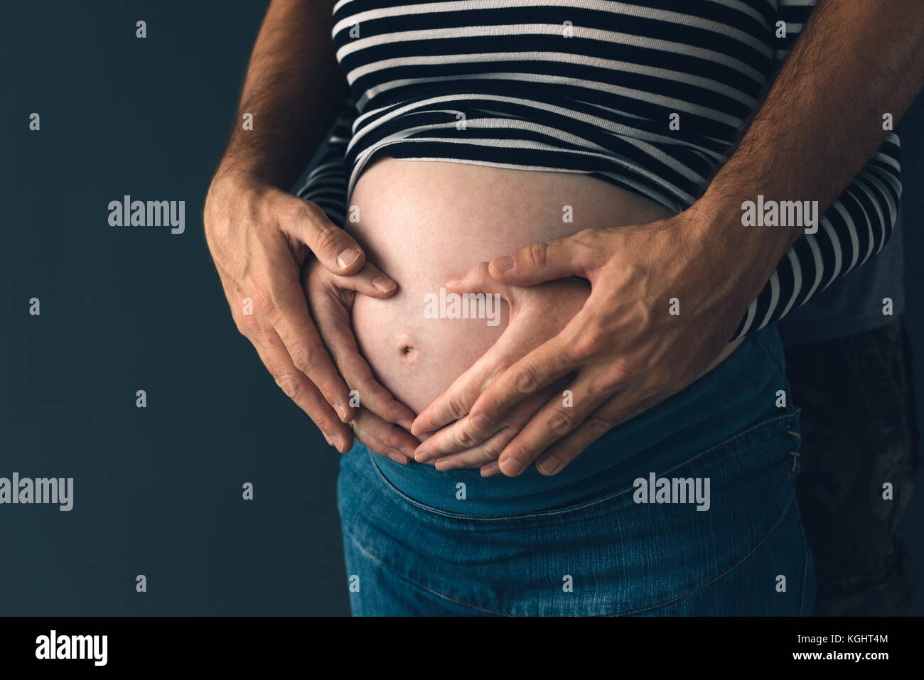 Soldier hugging sa femme enceinte, couple expecting baby, clé faible Banque D'Images