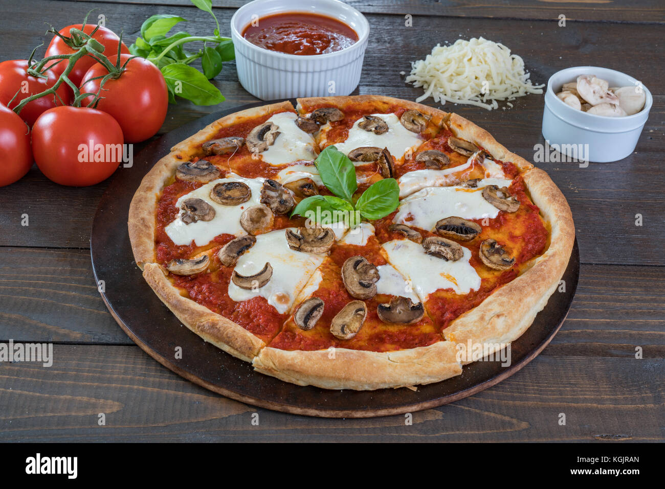 Fresh pizza chaude sur table en bois avec des ingrédients Banque D'Images