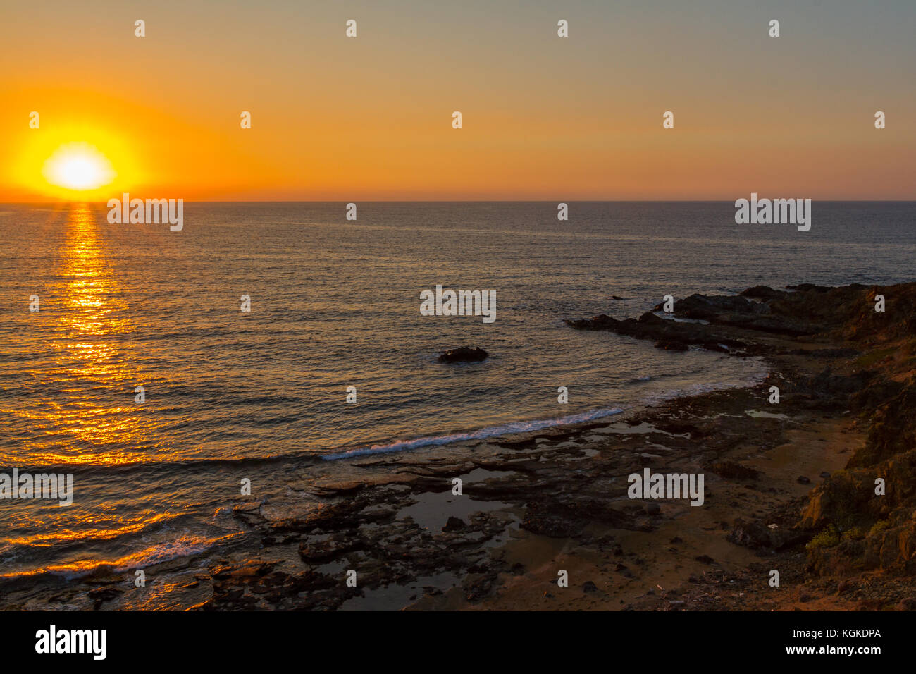 Coucher du soleil à une plage rocheuse dans pomos village, région de Paphos, l'île de Chypre Banque D'Images