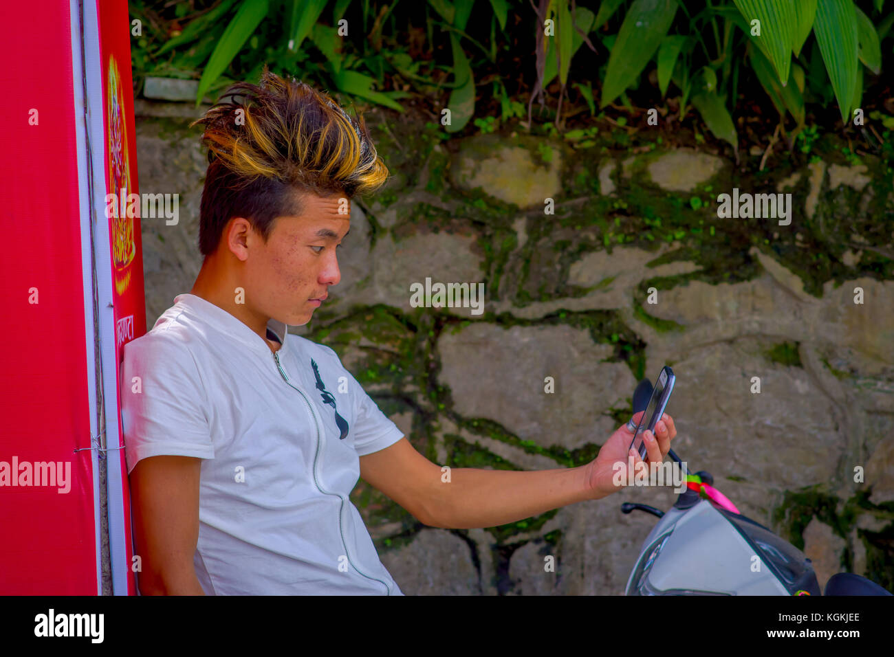 KATMANDOU, NÉPAL - 04 SEPTEMBRE 2017 : homme non identifié portant un t-shirt blanc et prenant un selfie avec son téléphone portable et posant pour la photo en plein air à Katmandou, Népal Banque D'Images KATMANDOU, NÉPAL - 04 SEPTEMBRE 2017 : homme non identifié portant un t-shirt blanc et prenant un selfie avec son téléphone portable et posant pour la photo en plein air à Katmandou, Népal Banque D'Images