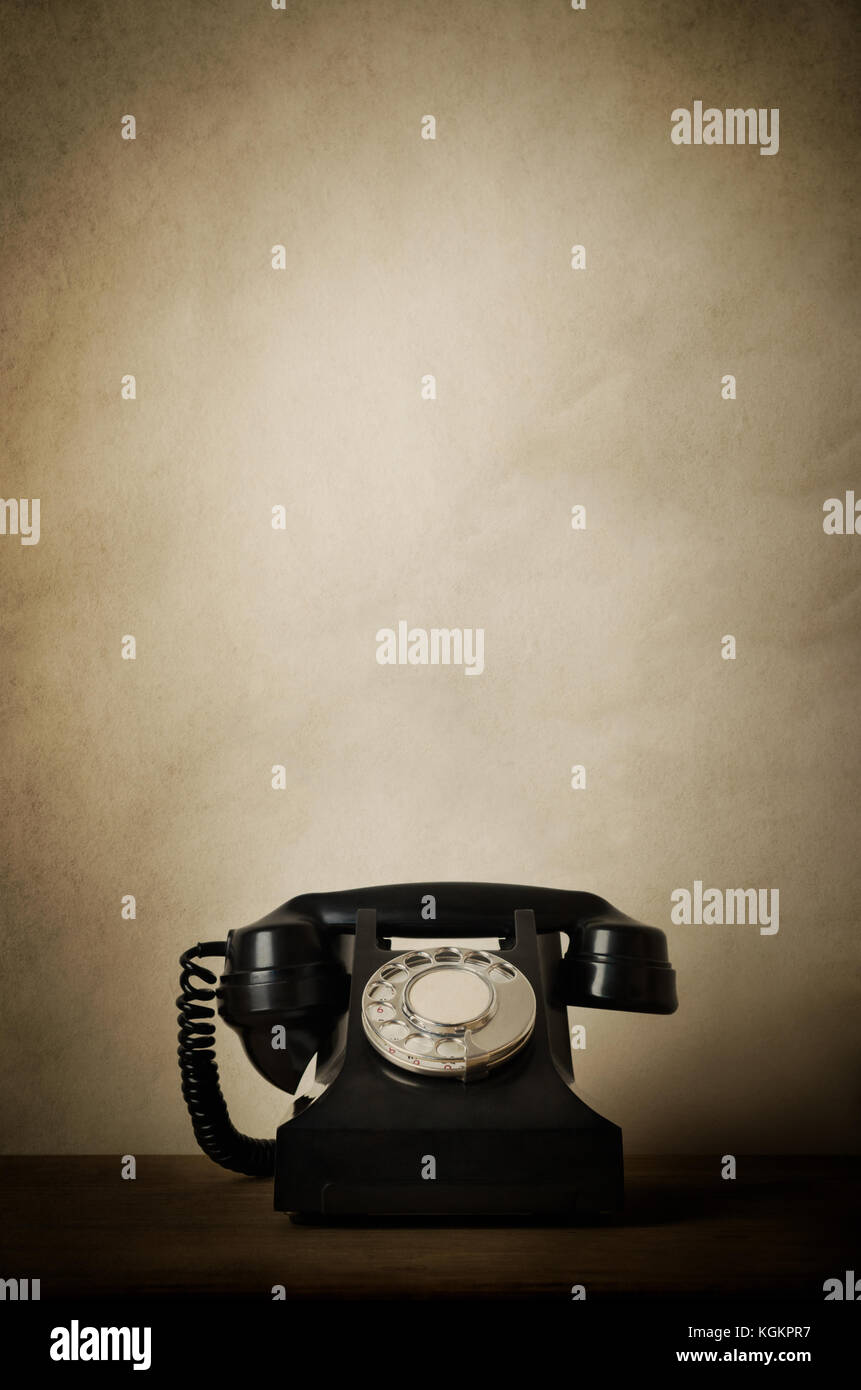 1940 noir téléphone bakélite vintage sur un bureau en bois avec personnes âgées, weathered éfauts et vignetted bords. copie espace ci-dessus. Banque D'Images