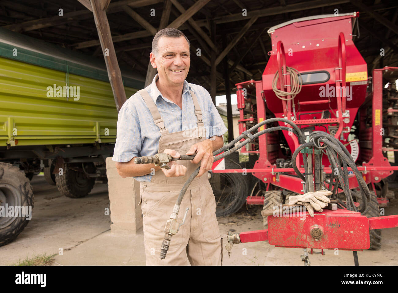 Mature agriculteur travaillant avec les machines agricoles Banque D'Images