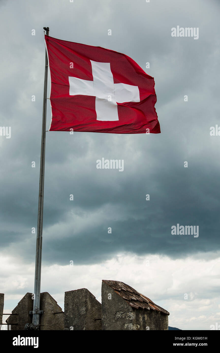 Low angle view of drapeau suisse clapote dans vent contre ciel nuageux Banque D'Images