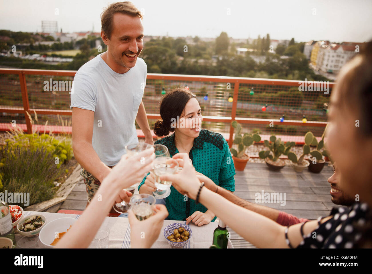 Heureux homme et femme friends toasting wineglasses on patio Banque D'Images
