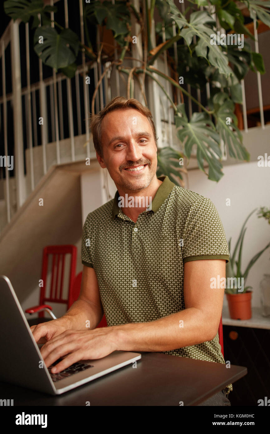 Portrait of happy Mid adult man using laptop Banque D'Images