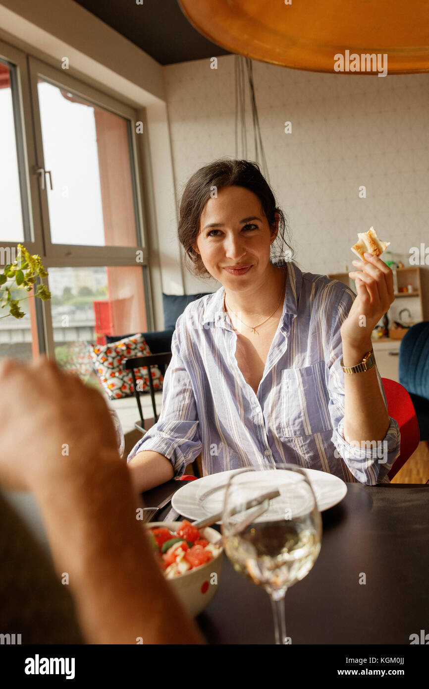 Smiling woman holding pain tout en regardant l'homme dans la chambre Banque D'Images