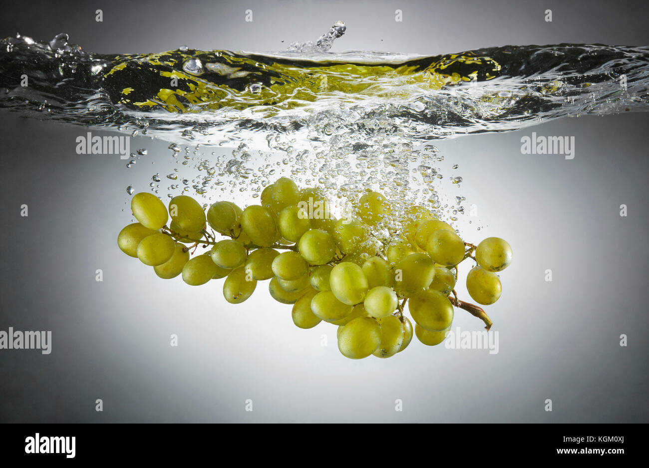 Close-up de raisins verts dans les projections d'eau. Banque D'Images
