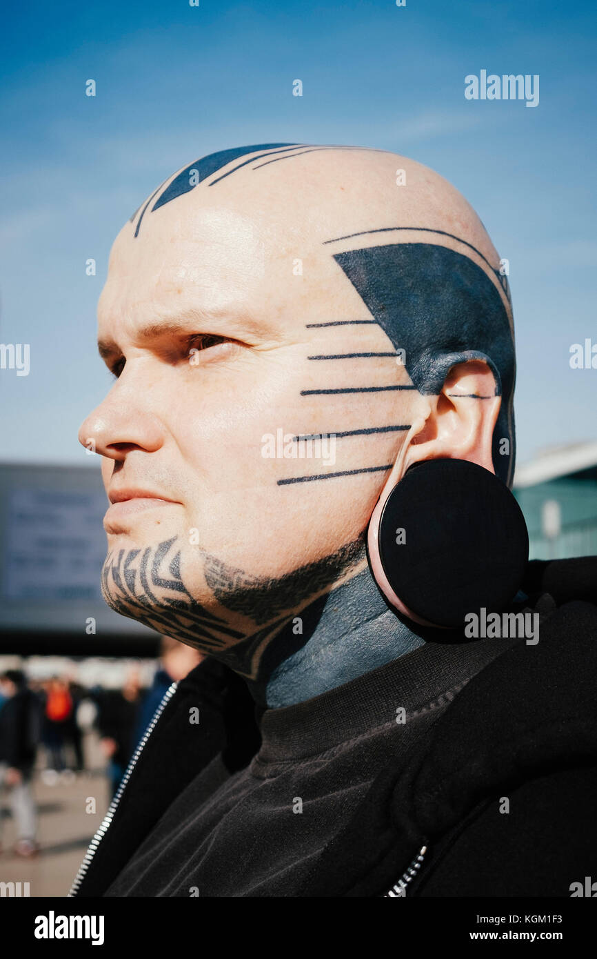 Close-up of man with tattoos et bouchon d'oreille contre le ciel Banque D'Images