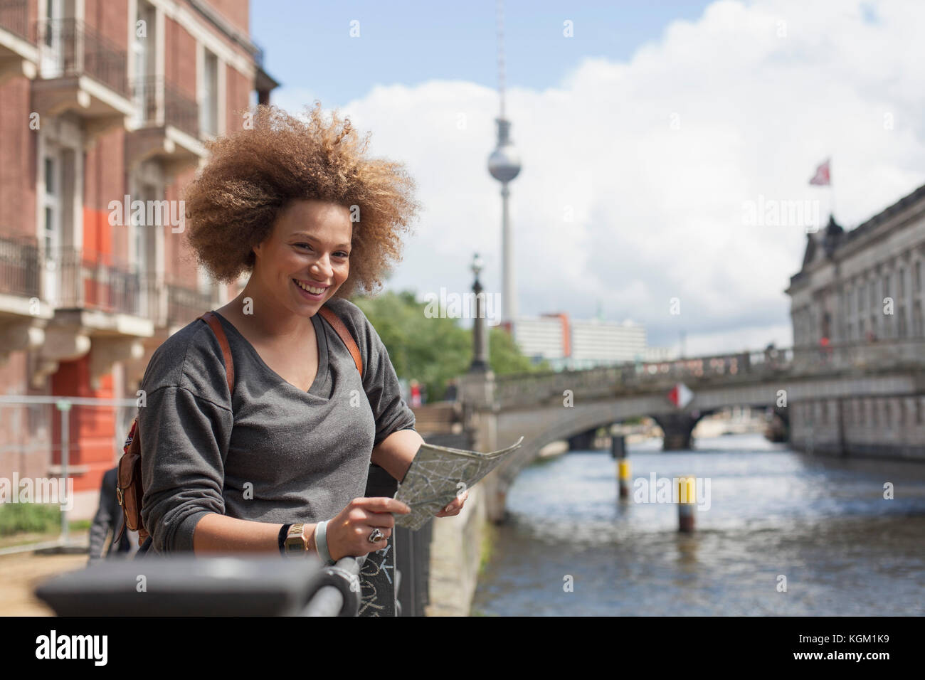Portrait of smiling woman standing with map contre Fernsehturm, Berlin, Allemagne Banque D'Images