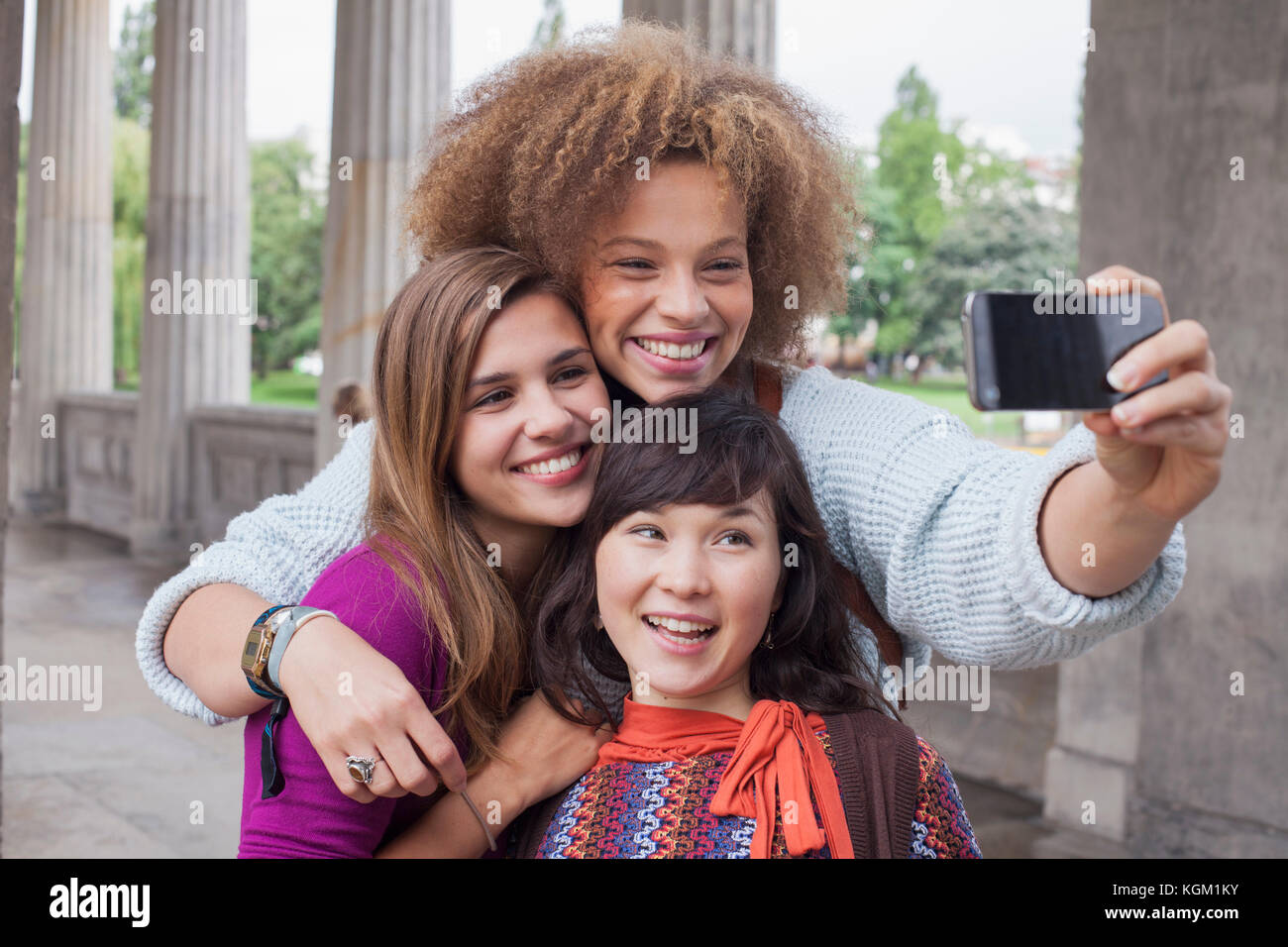 Jeune femme en tenant avec selfies female friends Banque D'Images