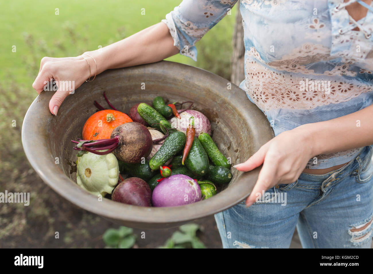 Midsection of woman holding vegetables in container Banque D'Images