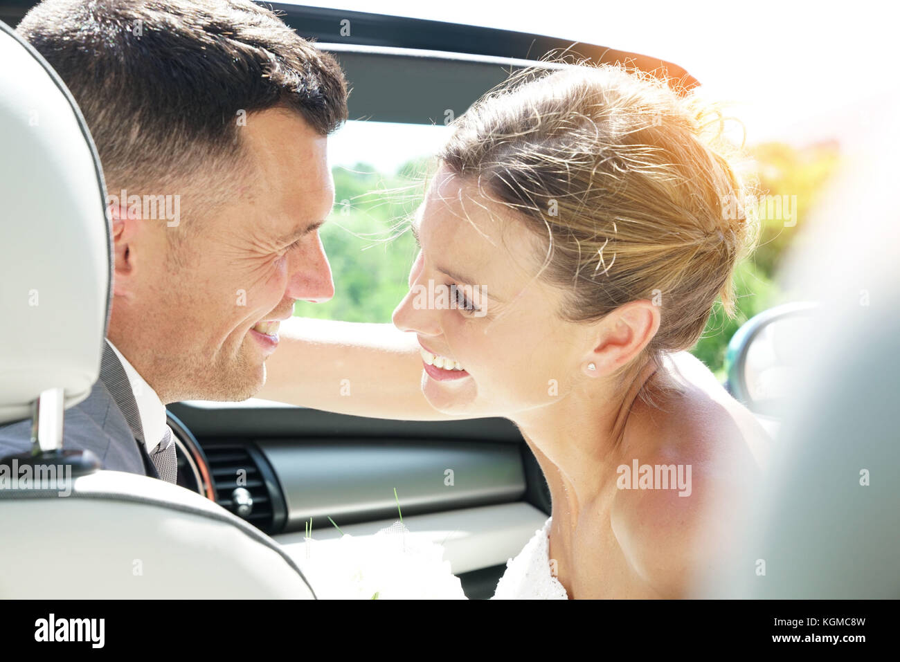 Récemment Mariés couple sitting in convertible car Banque D'Images