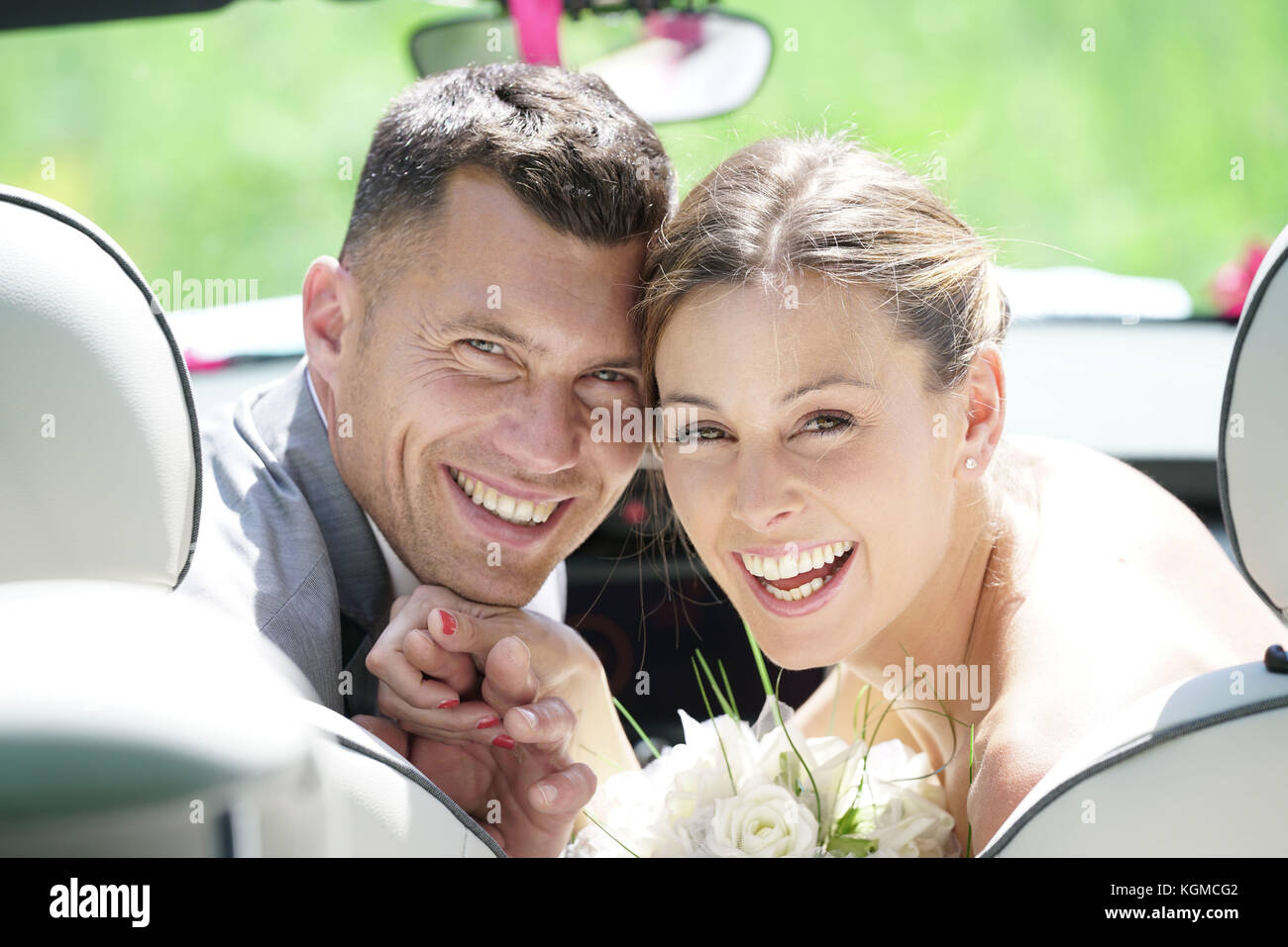 Bride and Groom sitting in convertible car Banque D'Images