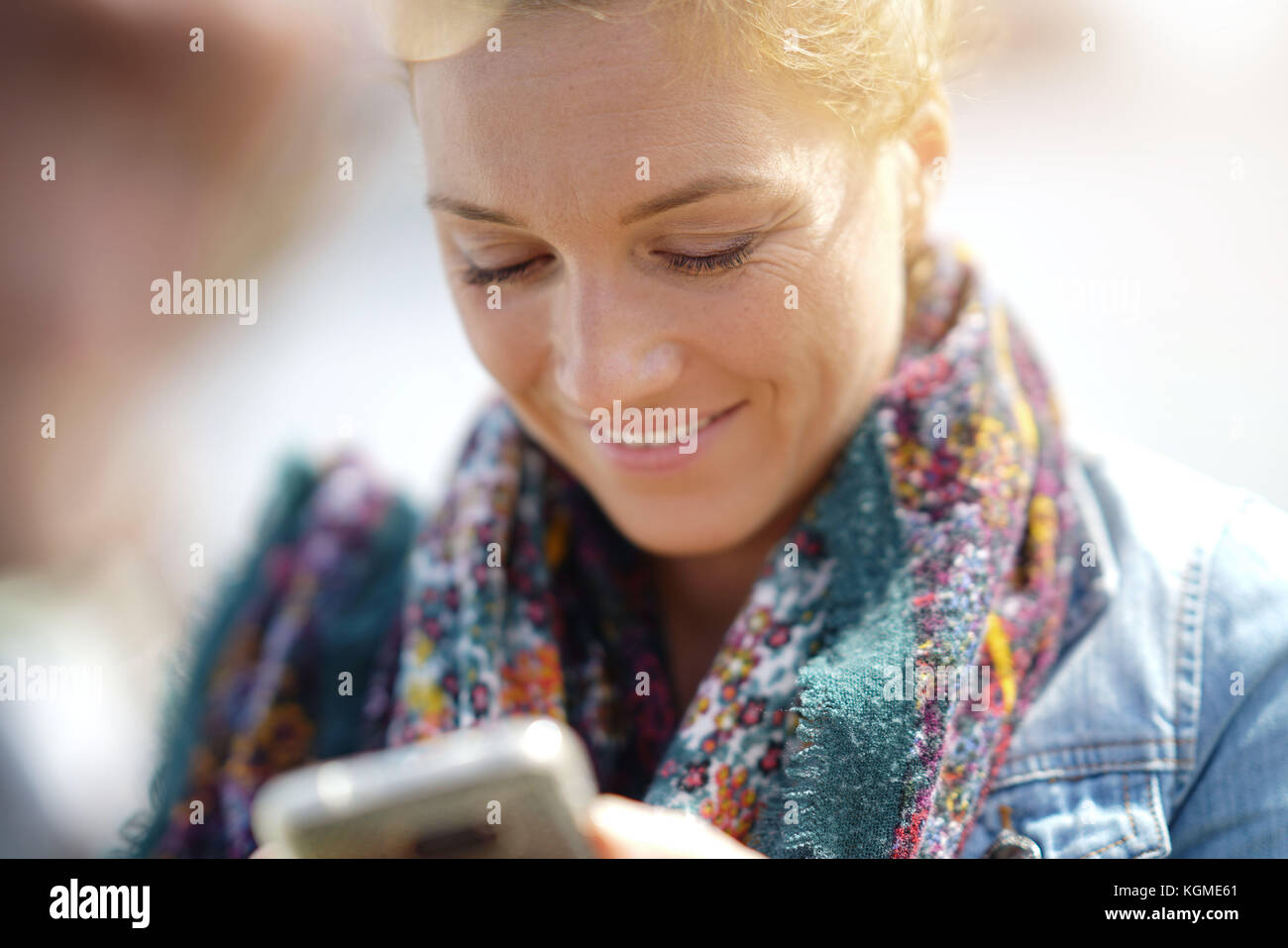 Gros plan du blond woman using smartphone Banque D'Images