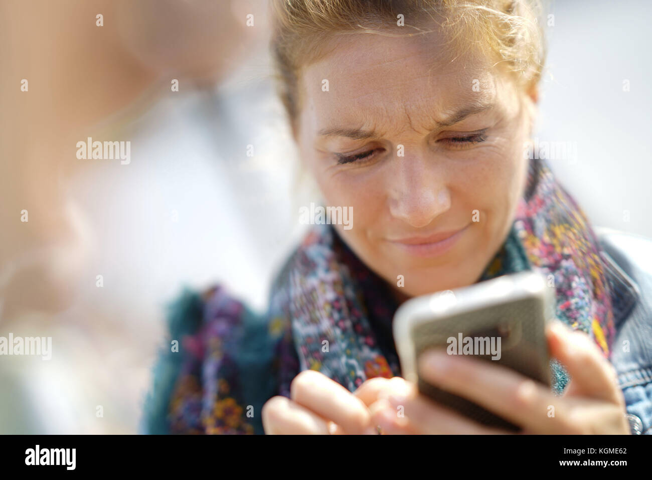 Gros plan du blond woman using smartphone Banque D'Images