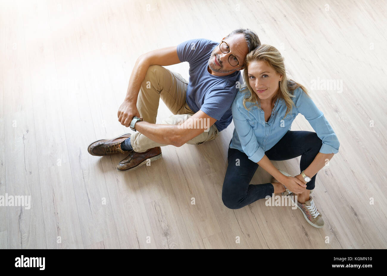 Vue supérieure du couple sitting on wooden floor at home Banque D'Images