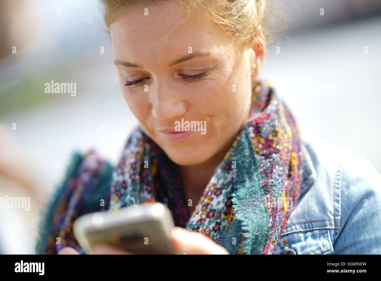 Gros plan du blond woman using smartphone Banque D'Images