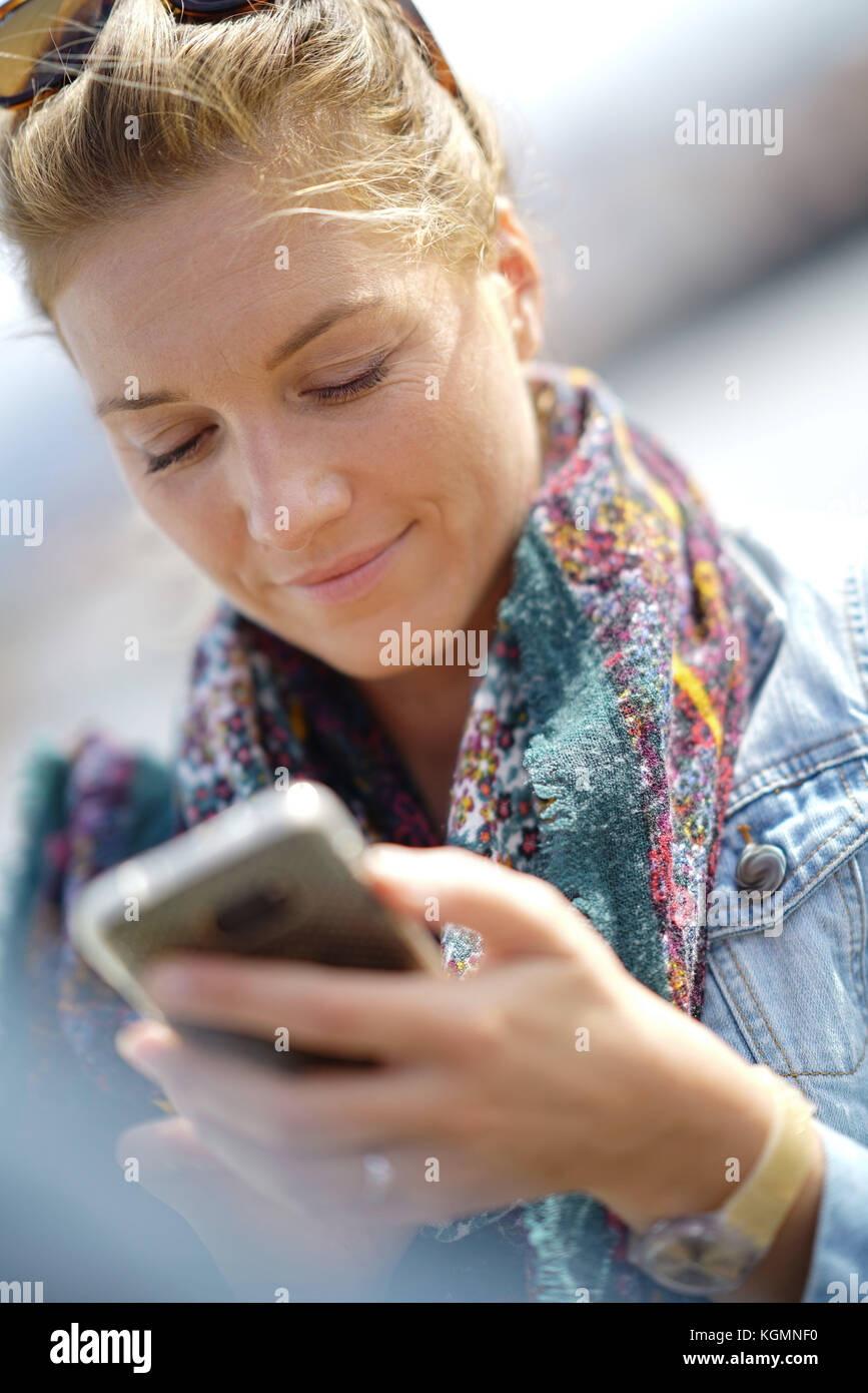 Gros plan du blond woman using smartphone Banque D'Images