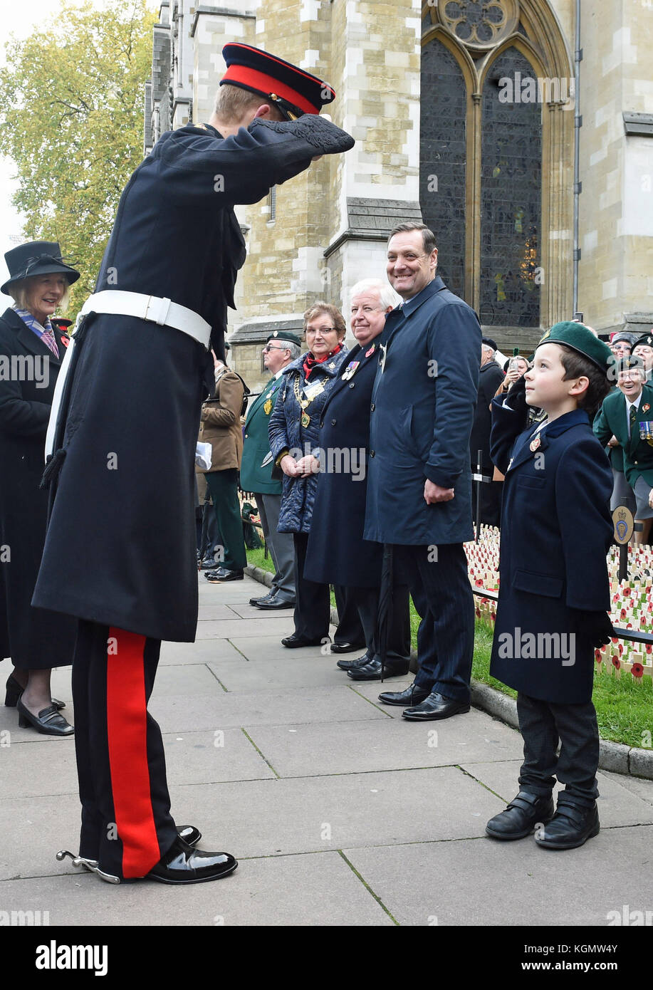 Le prince Harry salue un enfant au champ du souvenir de l'abbaye de Westminster où il honore les morts avant le jour de l'armistice. Banque D'Images