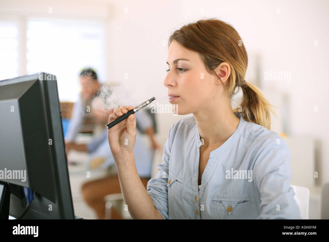 Fille de fumer avec la cigarette lectronique in office Photo Stock - Alamy