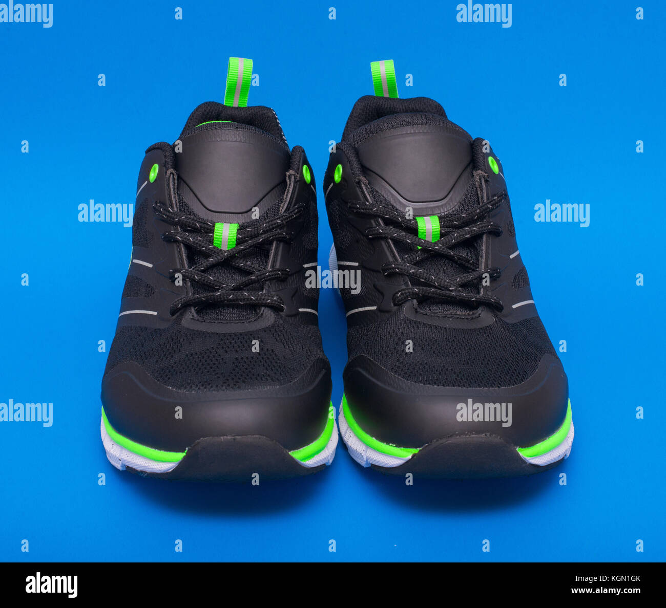 Paire de citron vert et noir sport chaussures unisexe isolé sur fond bleu Banque D'Images